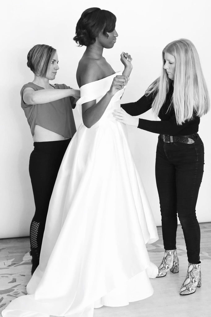 Image of Bride wearing a gown during an alteration appointment. 